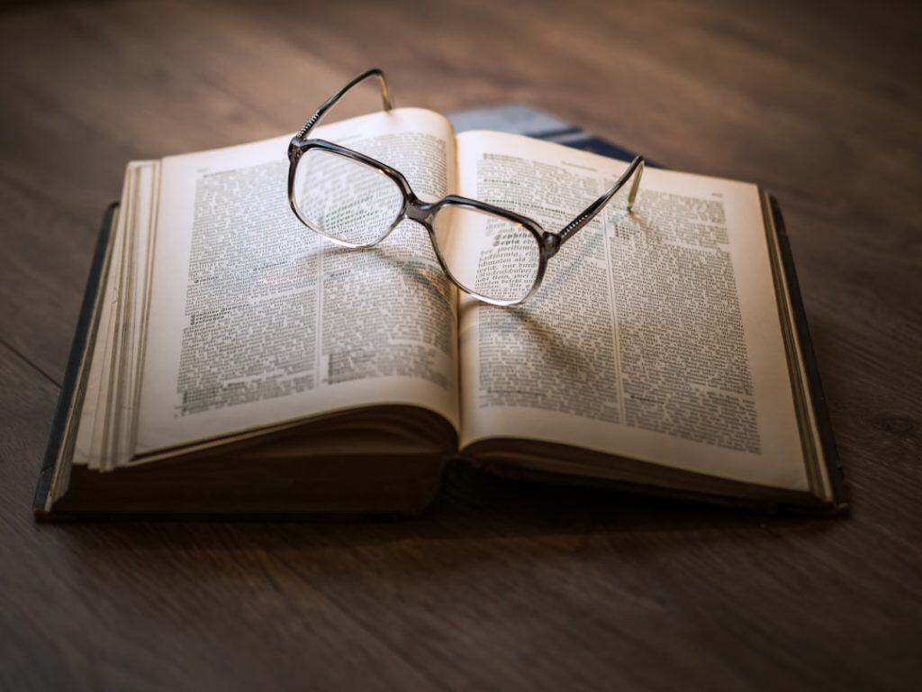 Legal book with reading glasses on open pages, symbolizing law and legal research.